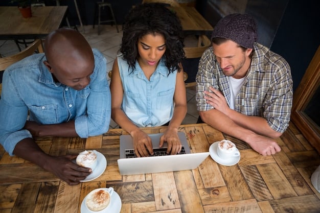 An image of a diverse team of startup employees collaborating closely around a table, with laptops and coffee cups, emphasizing teamwork and customer-centricity.