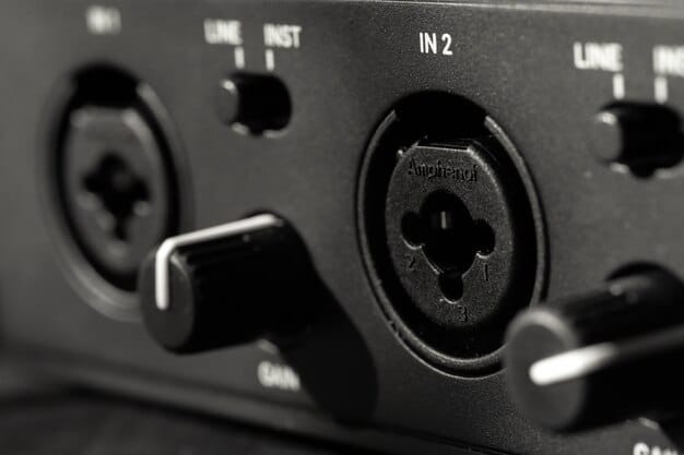 Close-up of the back panel of an audio interface, highlighting different types of inputs (XLR, 1/4 inch) and outputs (balanced TRS, RCA). Cables are plugged into some of the ports. The focus is on the variety and labeling of the connections.