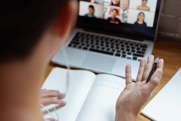 A close-up of a teacher facilitating a virtual classroom discussion on a laptop, with multiple student faces visible in a video conference grid, emphasizing interactive digital instruction and learning.