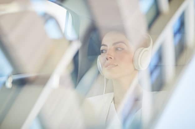 A person wearing the Aura headset in a modern office environment, appearing focused and undisturbed, with blurred background elements suggesting the effectiveness of noise cancellation.